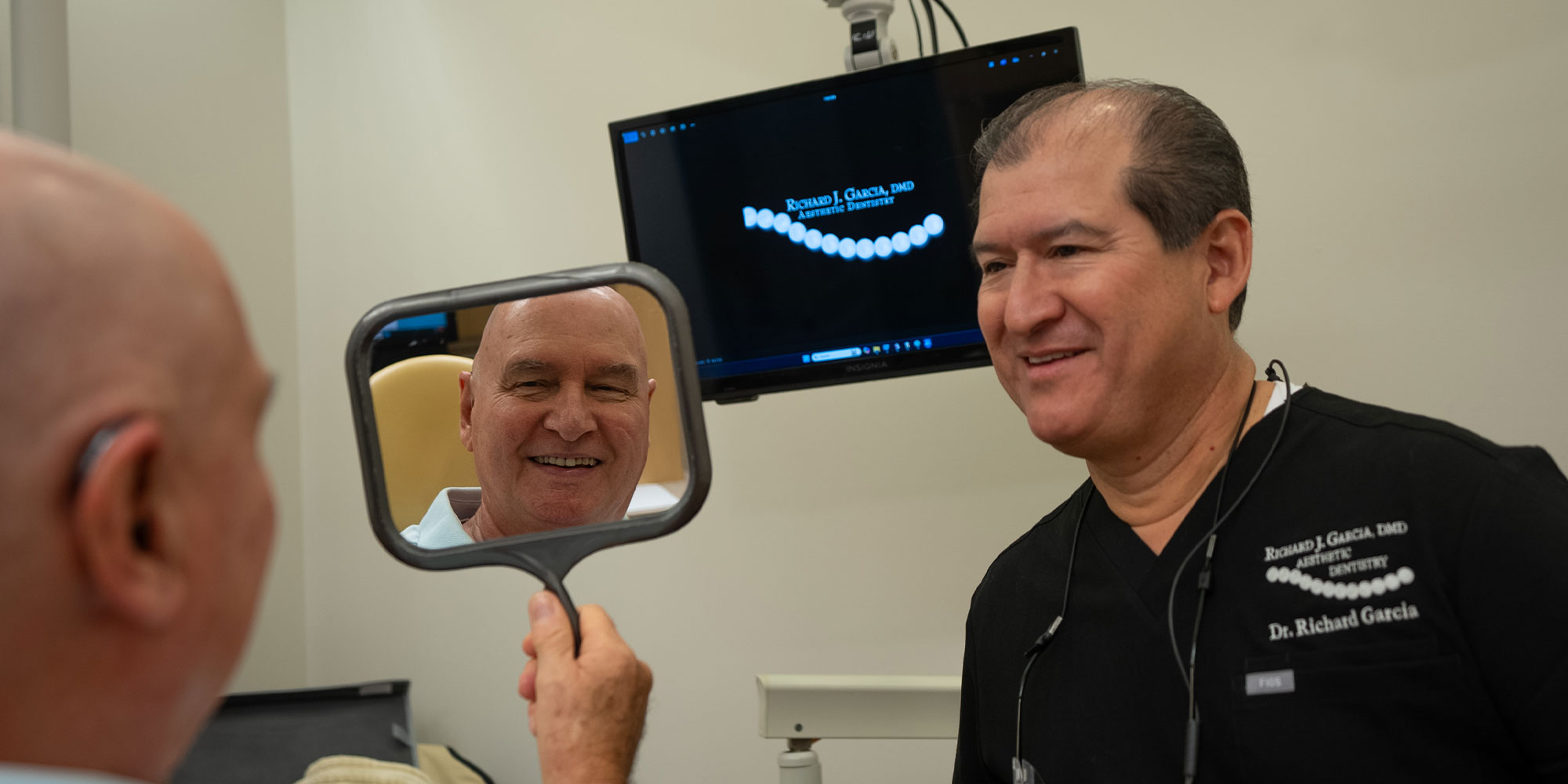 patient smiling brightly while looking in the mirror
