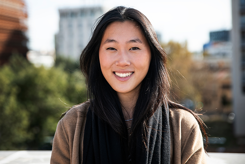 young female smiling brightly outside with her veneers