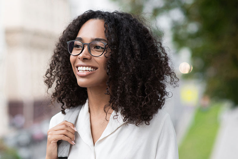 person smiling brightly while walking outside