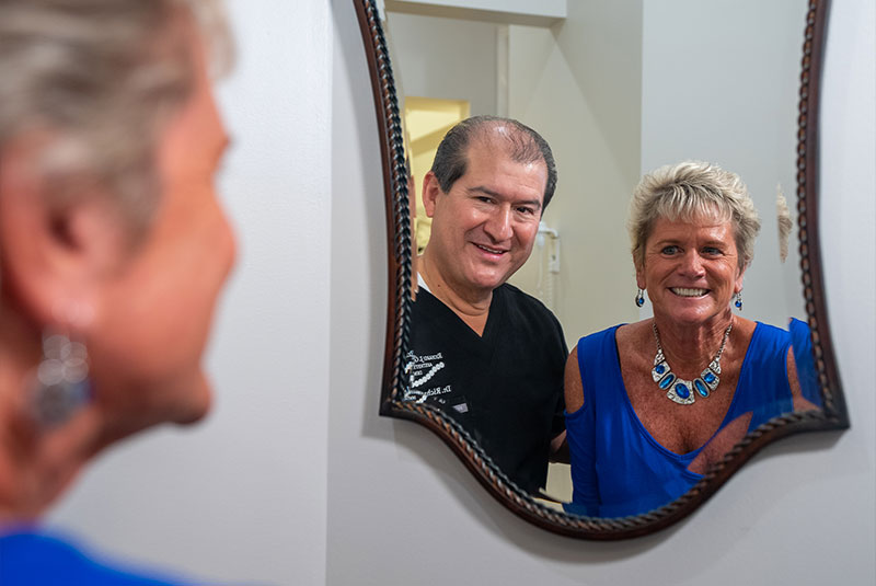 patient smiling in the mirror with doctor